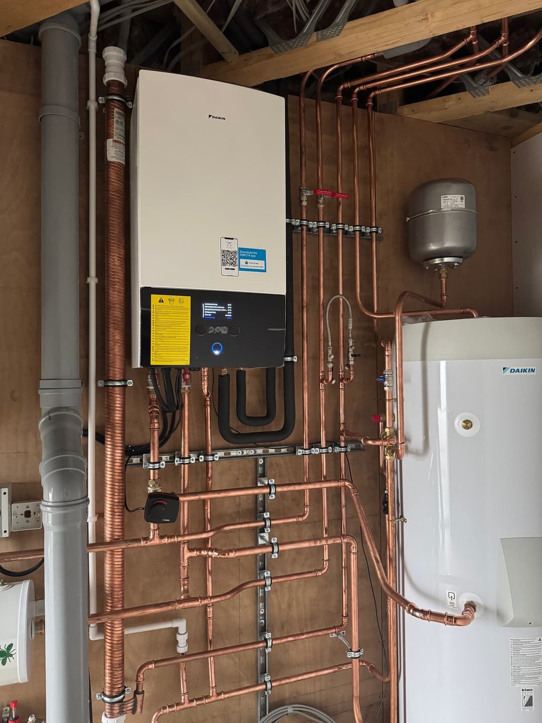 Neat copper pipework and a heat-pump cylinder in a plant room