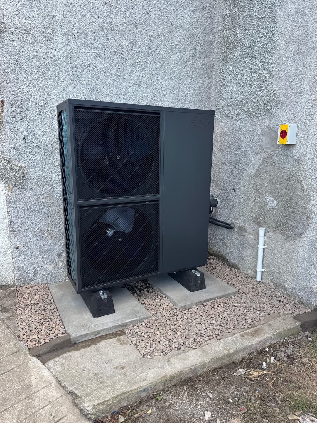 Large twin-fan air source heat pump on a gravel base
