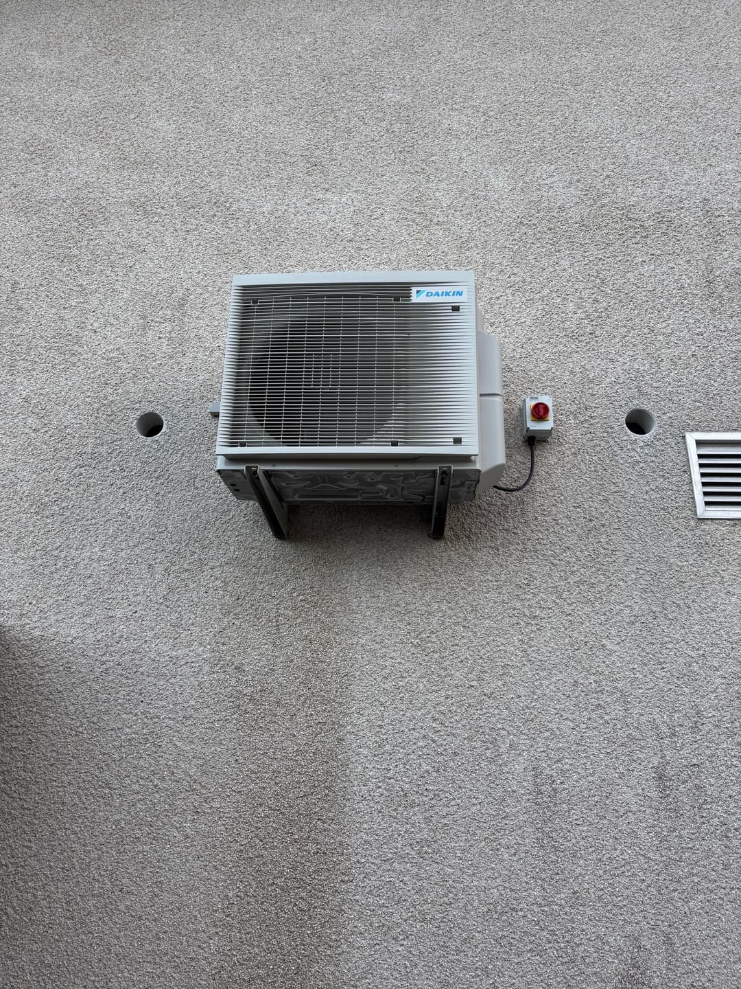 Daikin air source heat pump unit mounted on a house wall